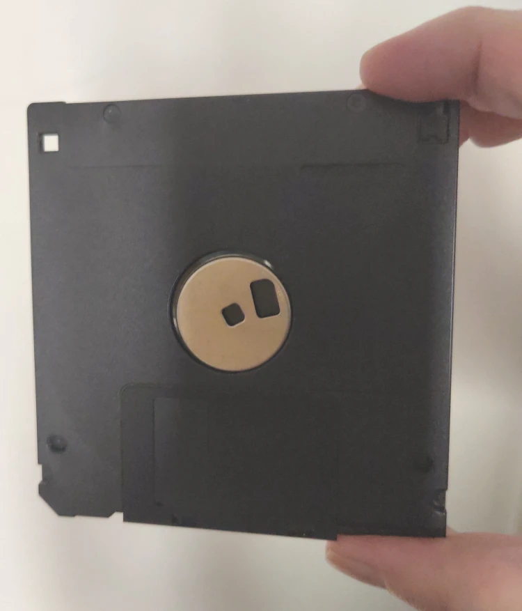 Disquette 3 pouces et demi de dos tenue entre le pouce et l'index