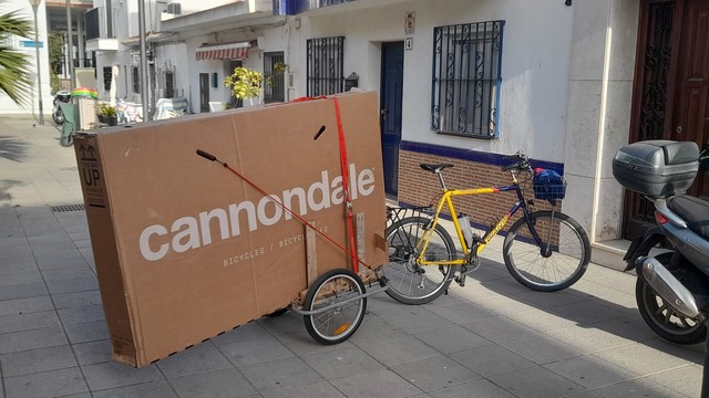 vélo avec remorque supportant un énorme carton